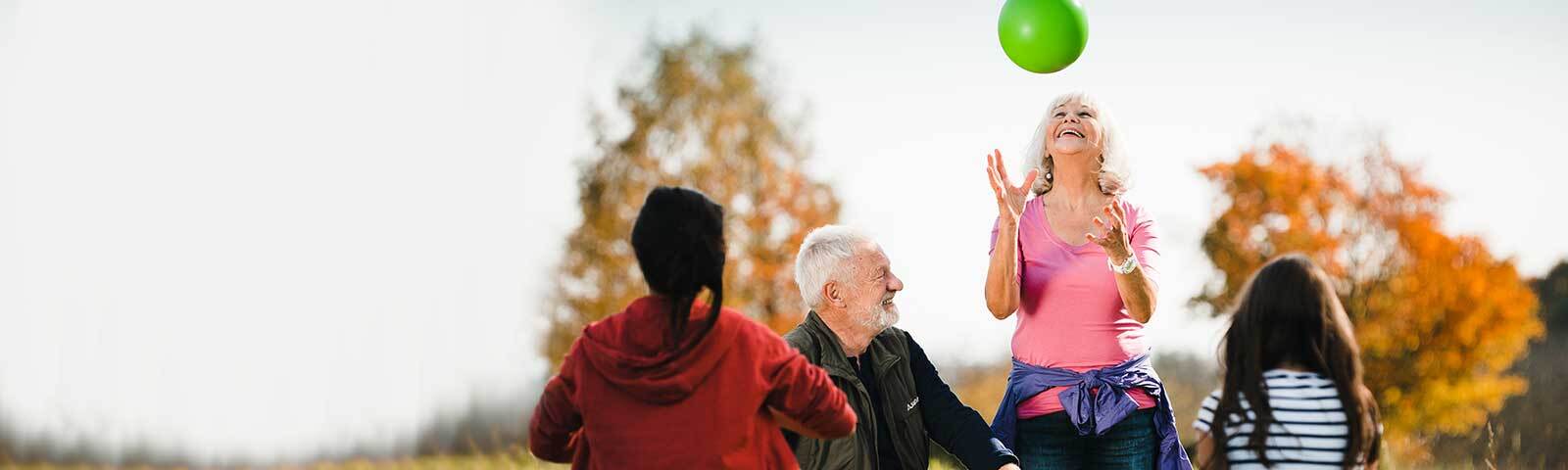 Koordination: Ältere Dame wirft grünen Ball in die Luft